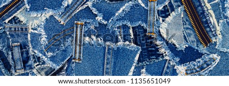 Denim blue jeans fabric frame. Ripped denim fabric , text place, copy space.   Destroyed torn denim blue jeans patches, banner background