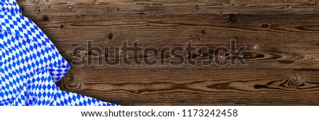 Oktoberfest background  frame  with bavarian white and blue fabric on brown wooden board. October fest banner background, copy space