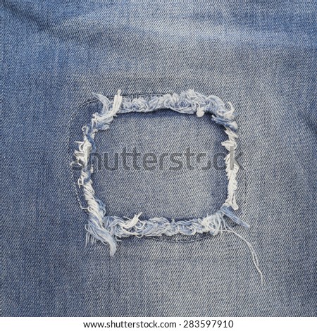 Close up of destroyed torn denim blue jeans patch