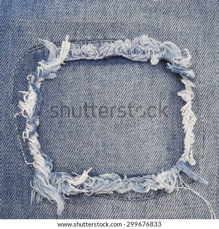 Destroyed torn denim blue jeans patch frame, close up