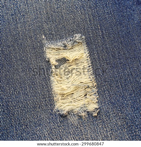 Close up of destroyed torn blue jeans