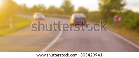 Blurred noise  image of two cars on the road turn.