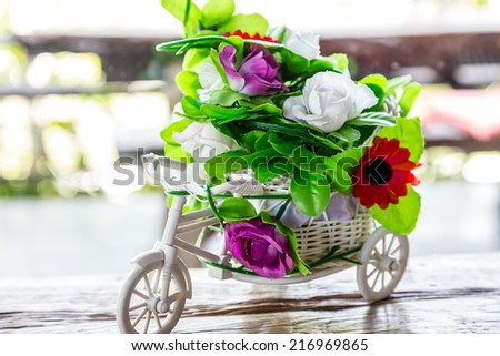 A bouquet of plastic flowers on bicycle tricycle flowers on bicycle tricycle