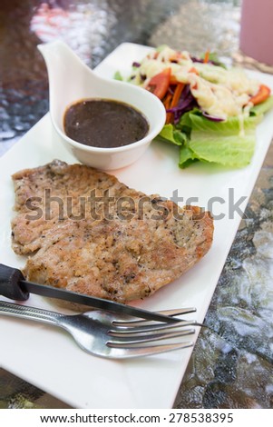 A dish of meat steak covered with herb