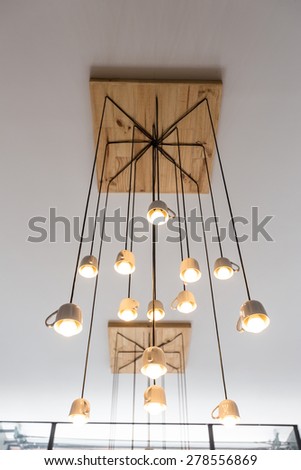 White mug lamp hanged on wooden tray on the ceiling