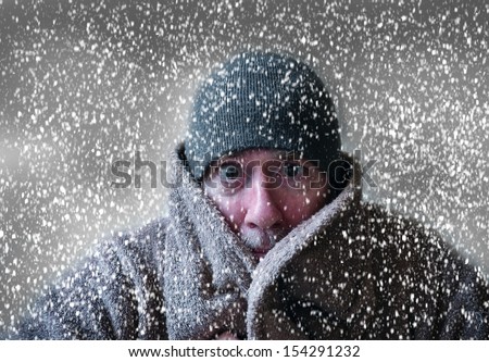 Man In Hat And Coat Shivering In Christmas Snowstorm With Cloudy Skies And Snowflakes Blowing In Wind Funny