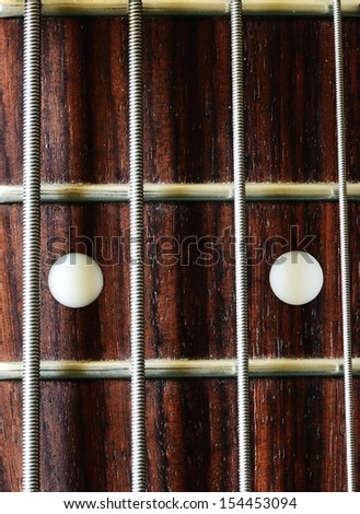Bass guitar rosewood fretboard and steel strings with frets and inlays at twelfth fret