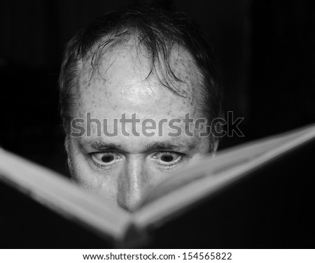 Good book, man engrossed with eyes unblinking