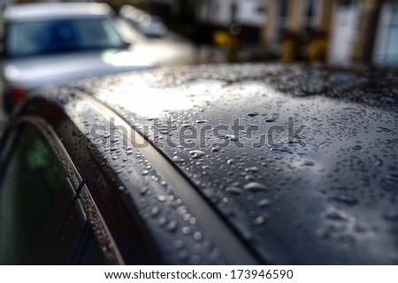 Rain on a car roof on a gloomy, dark winter morning.
