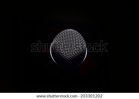 Microphone head on black stage background.