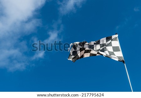 Weather-beaten racetrack finish flag or chequered flag.