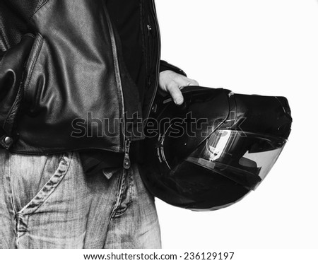 Biker in jeans and leather jacket holding motorcycle helmet on white background.