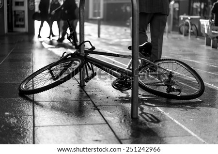 Sad, broken and discarded bicycle in a city centre with damaged and crooked wheel.