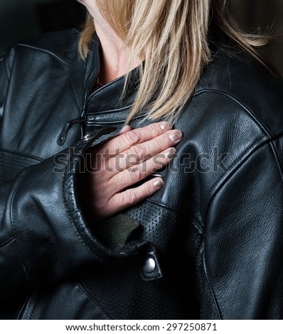 Middle aged lady biker with blonde hair in black leather motorcycle jacket
