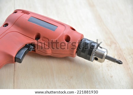 Electric drill tool isolated on wood background