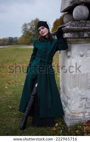 Girl in vintage green coat in the autumn park