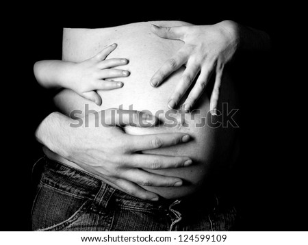 Hands and Belly - Pregnant woman belly holding hands of mother, father and child