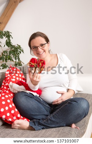 Beautiful pregnant mother with shoes her daughter