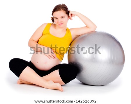 A pregnant woman doing a breathing exercise with an exercise ball