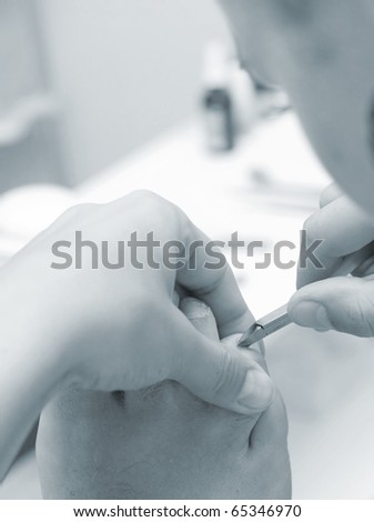 Cutting nails on foot in cosmetic salon