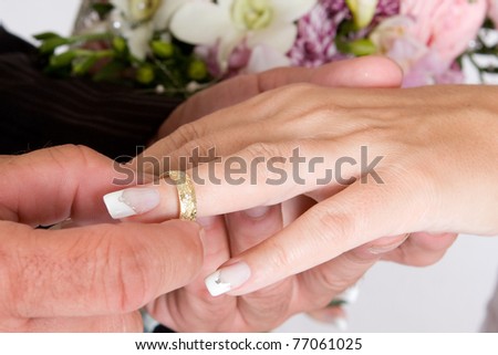 Groom putting wedding ring on bride`s finger