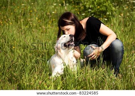 Photo of lady kissing her lovely dog in the open air