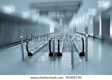 A view along a long moving walkway or moving sidewalk commonly used at modern airport terminals.