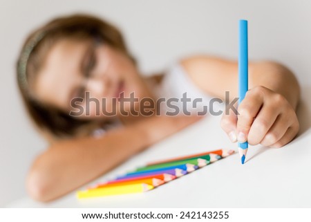 attractive school girl painting, focus on her painting hand