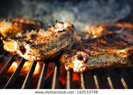 Rib steak on a hot grill BBQ with smoke and fire