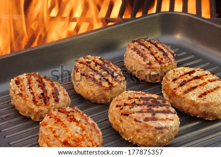 Burger on the grill pan and flames. You can see more BBQ food, flames and fire  on my page. Good luck in your art work!