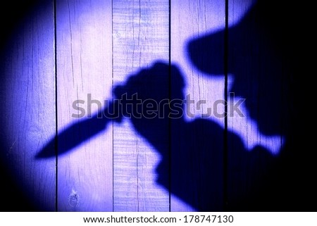 Male Shadow on the Wooden Background with a Hunting Knife in his Hand. You can see more silhouettes on my page. Good luck in your art work!