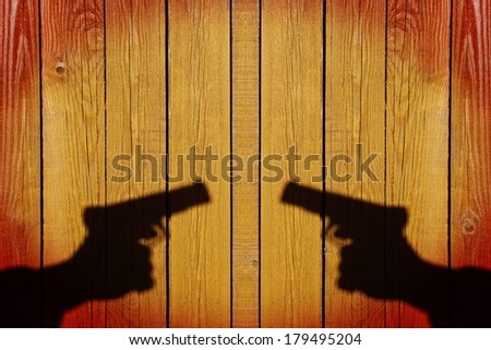 Silhouette of a hand with a gun on a wooden panel, grunge background with space for text or image