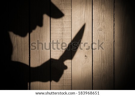 Armed Criminal Man Silhouette on natural wooden background with free space.You can see more silhouettes and shadows on my page.