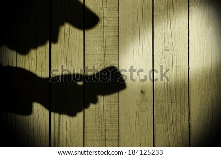 Silhouette with a Searchlight on Grungy Wooden Background.