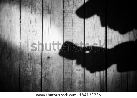 Detective Silhouette with a searchlight on Grungy Wooden Background.