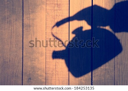 Hand Shadow with Kettle on the Natural Wooden Background, with space for text or image