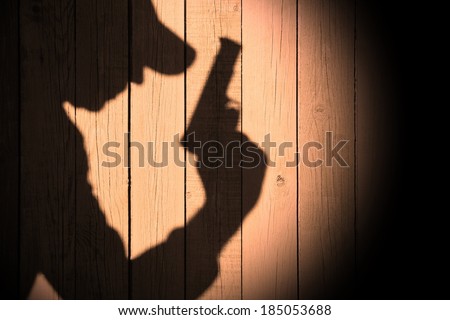 Investigator or Gangster or spy silhouette on natural wooden wall. You can see more silhouettes and shadows on my page.