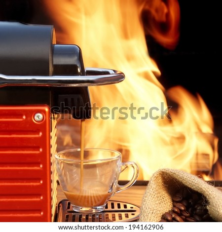 Coffee maker  with two cup of espresso surrounded by coffee beans and fire on the background