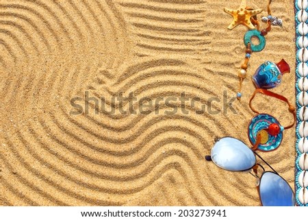 Sunglasses, shells, starfish, souvenirs, coin, pearl and other objects on the beach sand. Marine Summer Background.