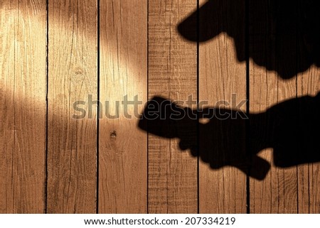 Male silhouette with searchlight on wooden wall. Background with space for text or image.