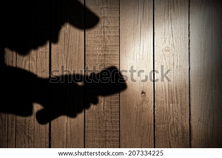 Male silhouette with searchlight on wooden wall. You can see more crime scene in my set