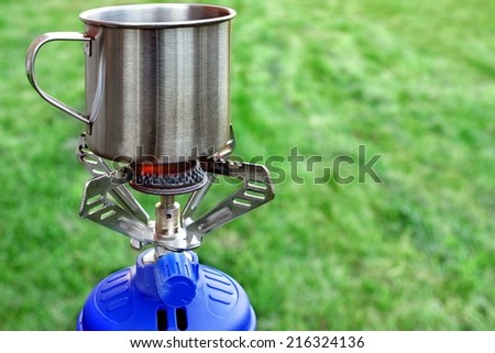 Camp Gas  Cooker and steel tea mug. Background with copy space
