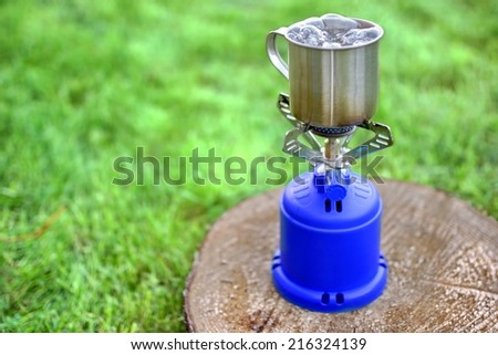 Camp Gas  Cooker and steel tea mug. Background with copy space