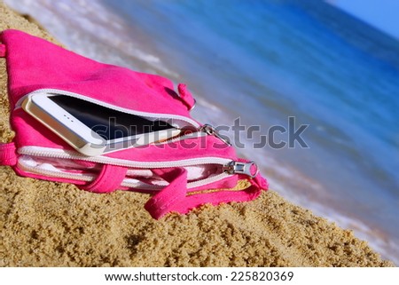 Smart Phone In Pink Female Purse on The Summer Sea Beach