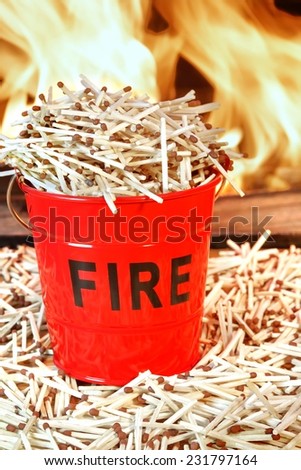Many Matches Around and In the Fire Bucket. Fire Flames in Background. Concept: DO NOT PLAY WITH FIRE, Dangerous