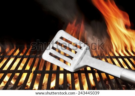 Spatula on the BBQ Hot Grill. Flames of Fire on the Background