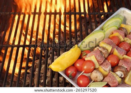 Meat And Vegetables Not Cooked Shish Kabobs On The Flaming Grill Close-up. Fire Of Flames In The Background.