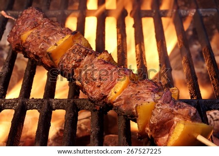 Beef Kebabs On The Hot BBQ Grill Closeup. Flaming  Charcoal Grill In The Background. Cookout Snack For Summer Spring Weekend  Barbecue or Picnic Party.
