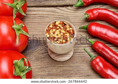 Hot Peppers, Ripe Fresh Tomatoes and Milled Chili Peppers Flakes and Corns On Rustic Wooden Table Background.  Ingredients for Soup, Salad, Paste