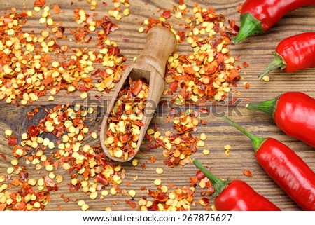 Hot Chili Peppers, Milled  Peppers Flakes and Corns In The Wood Spoon On Rustic Wooden Table Background.  Ingredients for Soup, Salad, Paste